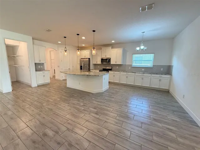a large kitchen with a large counter top appliances and cabinets