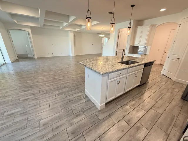 a kitchen with a sink cabinets and wooden floor