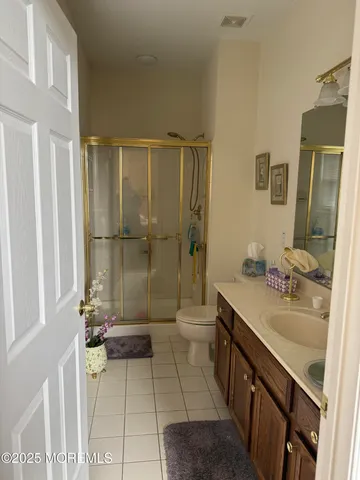 a bathroom with a granite countertop sink a toilet and shower