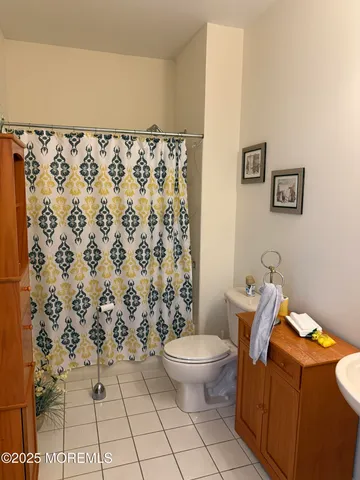 a bathroom with a toilet and a shower curtain