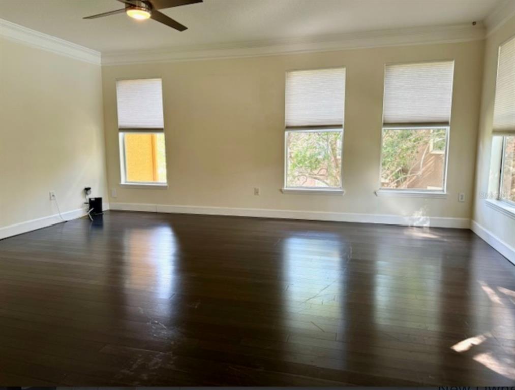 8843 Villa View Circle, Unit 207 Orlando, FL 32821 - Photo 11 of 36 a view of empty room with wooden floor and fan