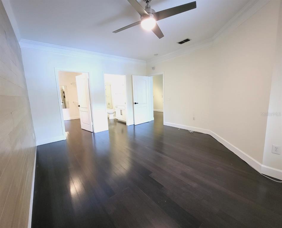8843 Villa View Circle, Unit 207 Orlando, FL 32821 - Photo 15 of 36 an empty room with wooden floor and ceiling fan