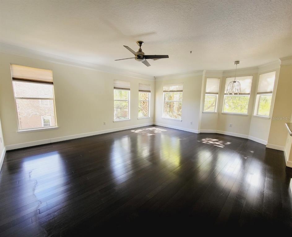 8843 Villa View Circle, Unit 207 Orlando, FL 32821 - Photo 9 of 36 a view of empty room with wooden floor and fan