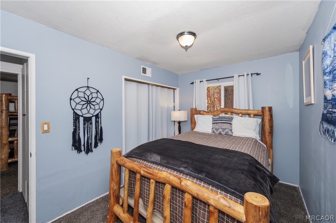 1099 Canyon Road Fawnskin, CA 92333 - Photo 19 of 39 a bedroom with a bed and dresser