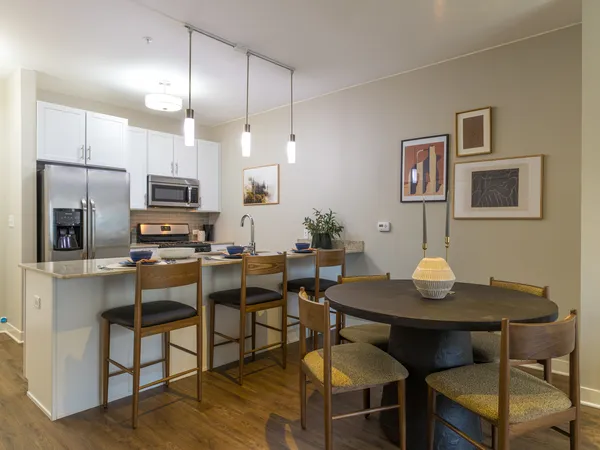 a living room with furniture and a dining table with kitchen view