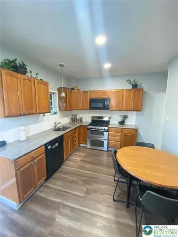 a kitchen with stainless steel appliances a refrigerator and a table