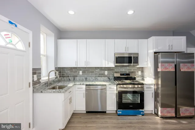 a kitchen with white cabinets stainless steel appliances and sink