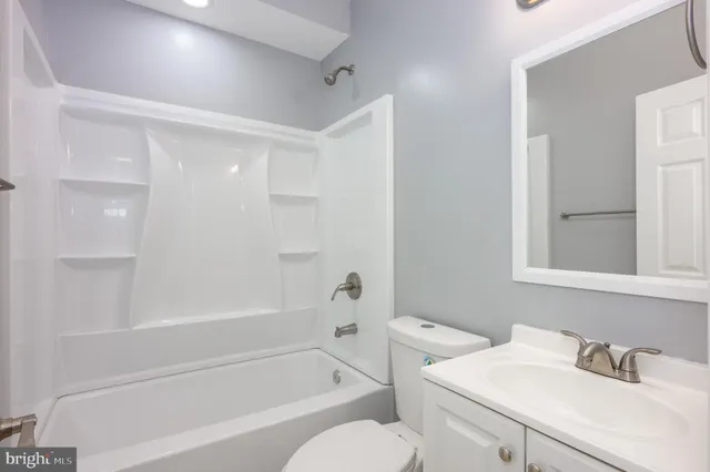 a white bath tub sitting next to a white sink and a toilet