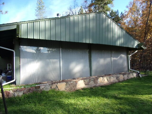 Wall of windows from sunroom (blinds drawn for focus) overlooking beautiful views.