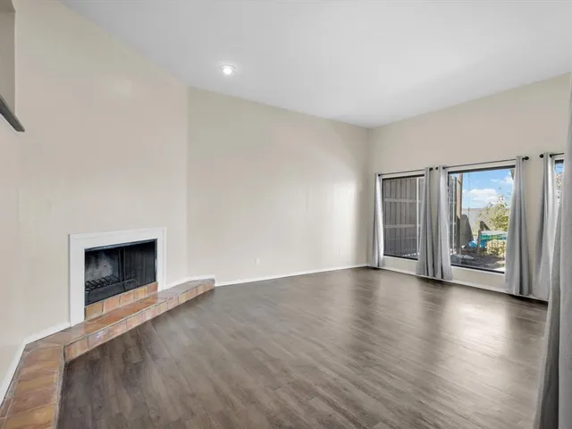 an empty room with wooden floor and fireplace