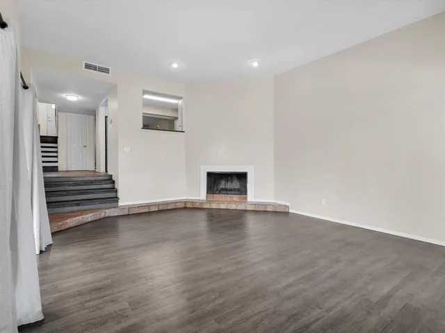 an empty room with wooden floor and fireplace