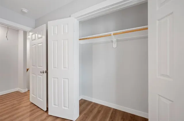 a view of walk in closet with wooden floor