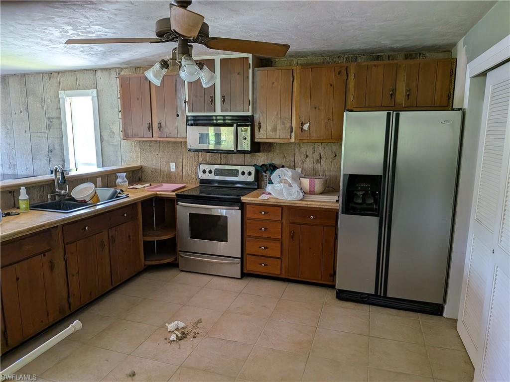 17191 Frank Road Alva, FL 33920 - Photo 22 of 27 a kitchen with stainless steel appliances granite countertop a refrigerator a sink a stove and white cabinets