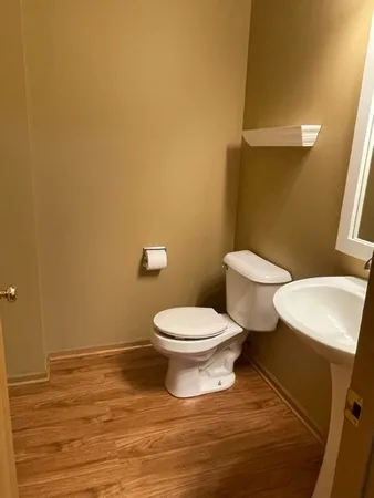 a white toilet sitting next to a white sink and vanity