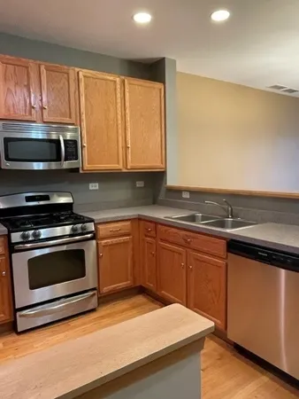 a kitchen with granite countertop wooden cabinets stainless steel appliances and a window