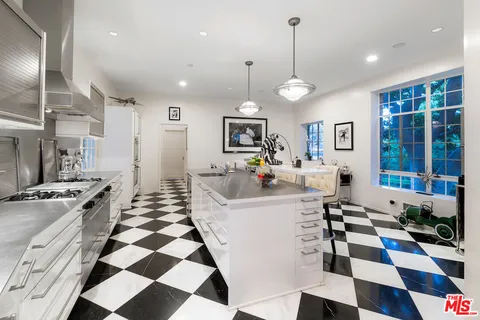 a kitchen with stainless steel appliances granite countertop a stove a sink and a chandelier