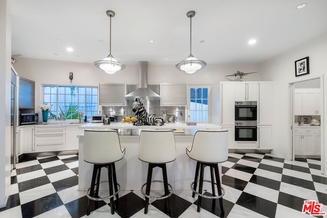 601 Woodruff Avenue Los Angeles, CA 90024 - Photo 14 of 39 a kitchen with stainless steel appliances granite countertop a stove a sink and a chandelier