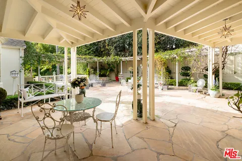 a view of a patio with table and chairs and potted plants