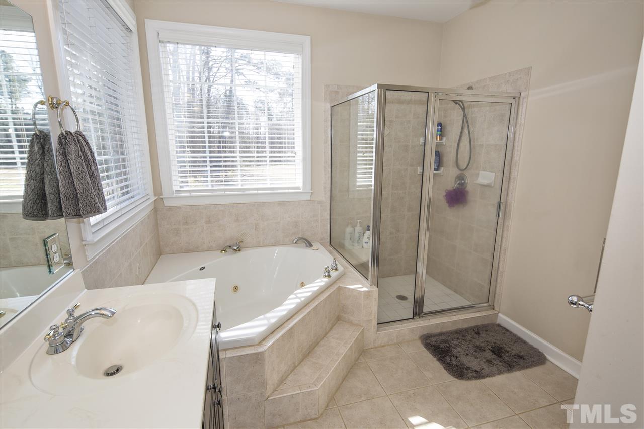 6407 Wimberly Road Willow Spring, NC 27592 - Photo 17 of 25 a bathroom with a tub a sink and a shower