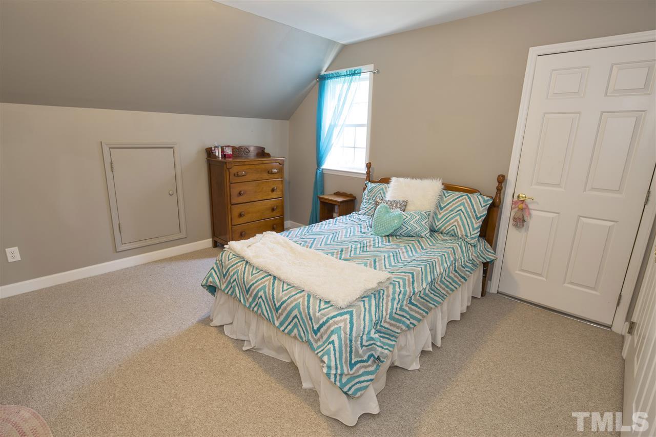 6407 Wimberly Road Willow Spring, NC 27592 - Photo 19 of 25 a bedroom with a bed and a table