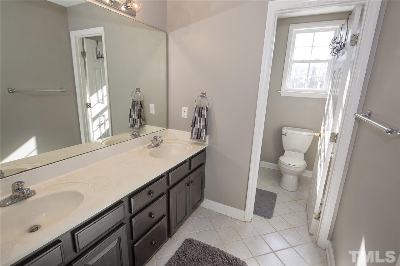 6407 Wimberly Road Willow Spring, NC 27592 - Photo 20 of 25 a bathroom with a sink a toilet and a mirror