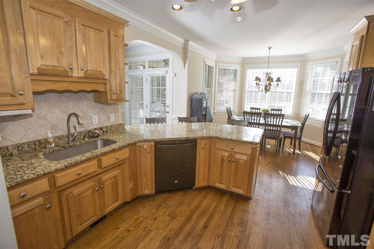 6407 Wimberly Road Willow Spring, NC 27592 - Photo 9 of 25 a kitchen with stainless steel appliances granite countertop wooden floors and sink