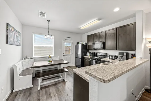 a kitchen with granite countertop a refrigerator stove and sink