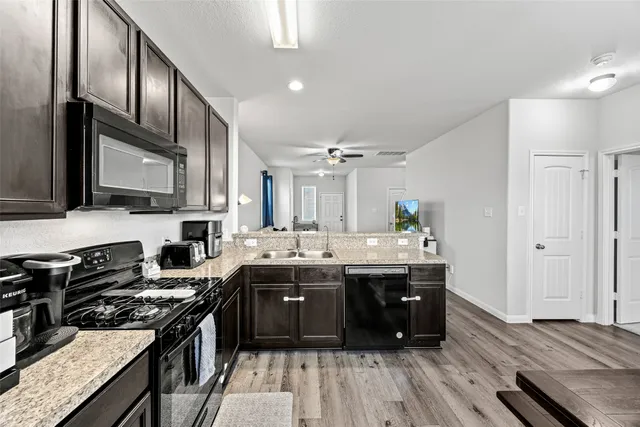 a kitchen with sink refrigerator and cabinets