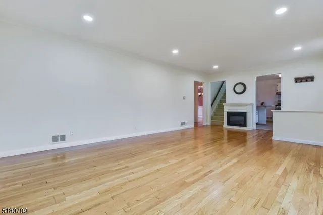 a view of empty room with wooden floor and fireplace