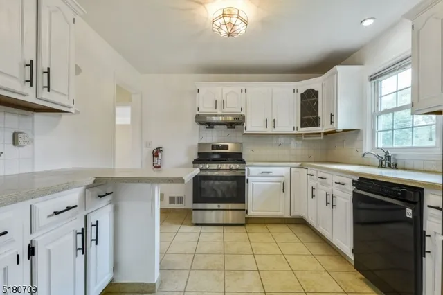 a kitchen with stainless steel appliances granite countertop a stove sink and cabinets