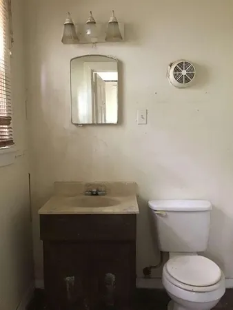 a bathroom with a toilet sink and mirror