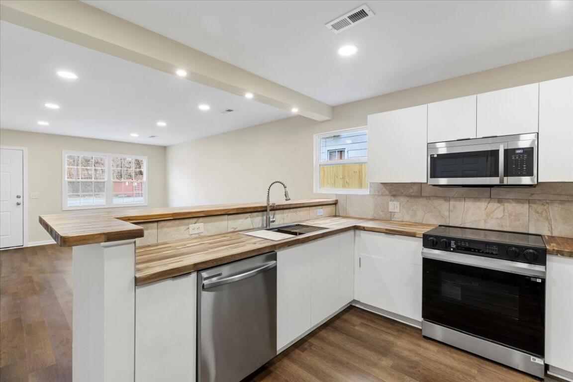 138 Pierce Avenue Pulaski, VA 24301 - Photo 15 of 40 a kitchen with stainless steel appliances granite countertop a sink and a stove top oven with wooden floor
