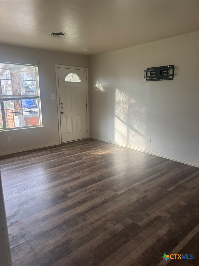 904 Houston Street Killeen, TX 76541 - Photo 8 of 17 an empty room with wooden floor and windows