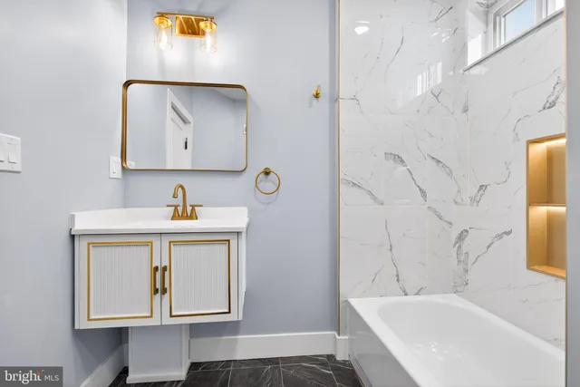 a bathroom with a tub sink and mirror