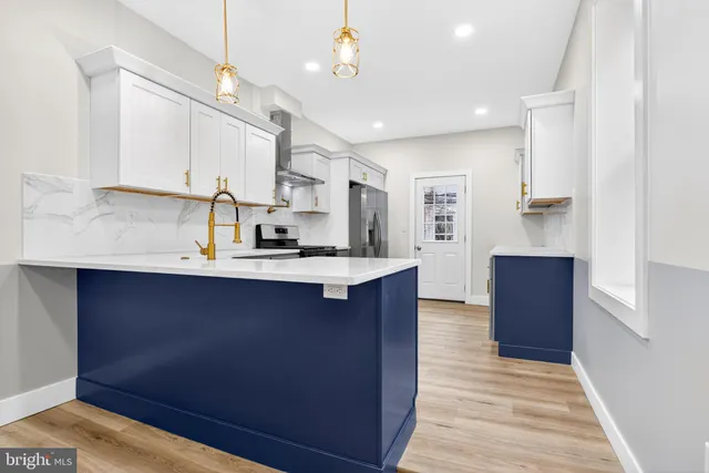 a kitchen with stainless steel appliances granite countertop a sink a stove and a wooden floors