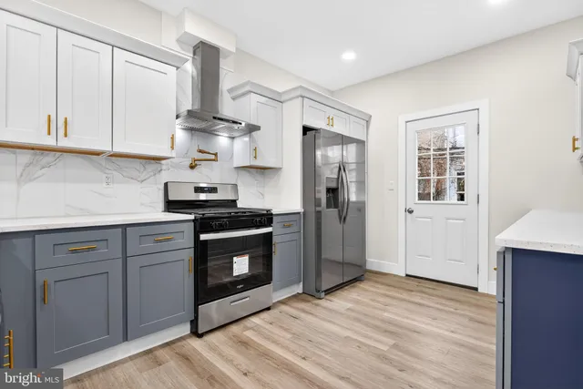 a kitchen with stainless steel appliances granite countertop a stove a sink and a refrigerator