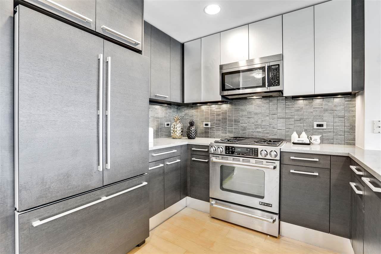 2 2nd Street, Unit 2803 Jersey City, NJ 07302 - Photo 11 of 28 a kitchen with stainless steel appliances white cabinets and a stove top oven