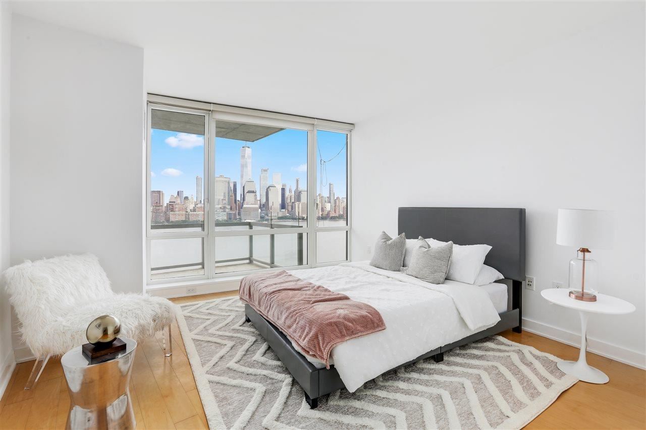 2 2nd Street, Unit 2803 Jersey City, NJ 07302 - Photo 14 of 28 a bedroom with a bed and glass window