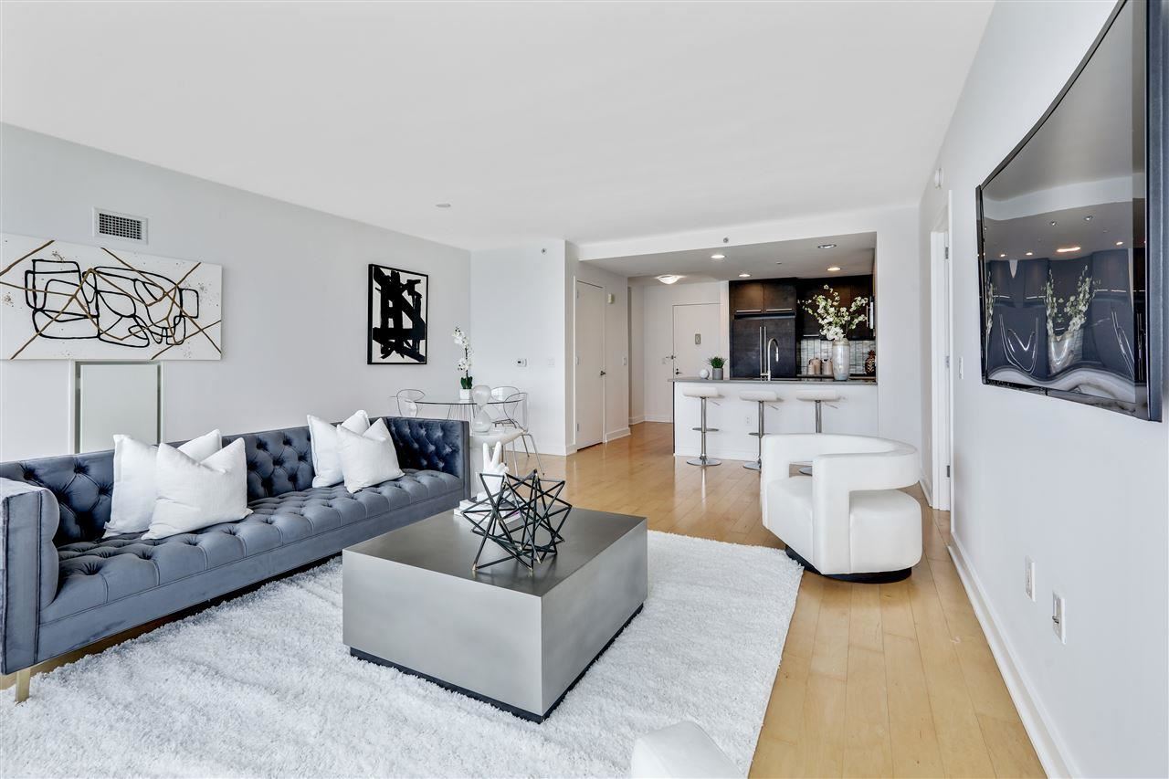 2 2nd Street, Unit 2803 Jersey City, NJ 07302 - Photo 3 of 28 a living room with furniture and a large window