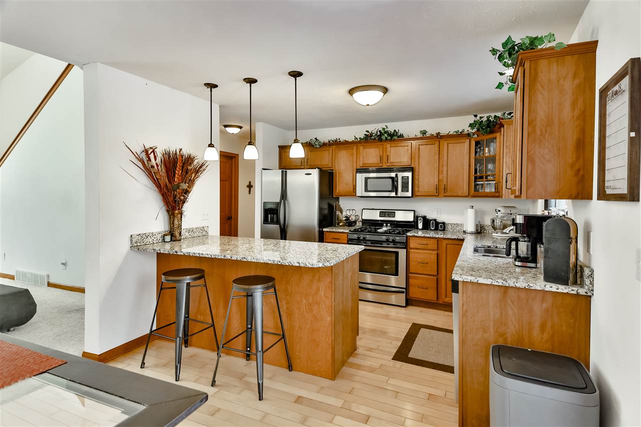 312 Rochester Road Northeast Poplar Grove, IL 61065 - Photo 9 of 28 a kitchen with stainless steel appliances granite countertop a sink a stove and a refrigerator
