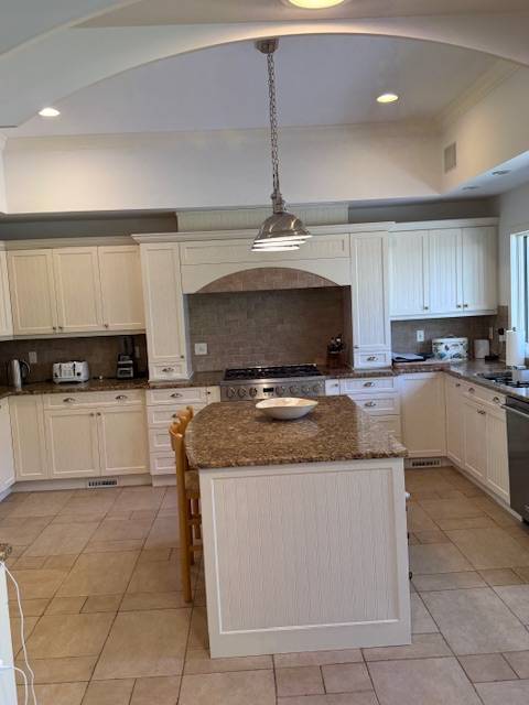 3 Stone Lane Quogue, NY 11959 - Photo 27 of 35 a kitchen with kitchen island granite countertop a sink a counter top space cabinets and stainless steel appliances