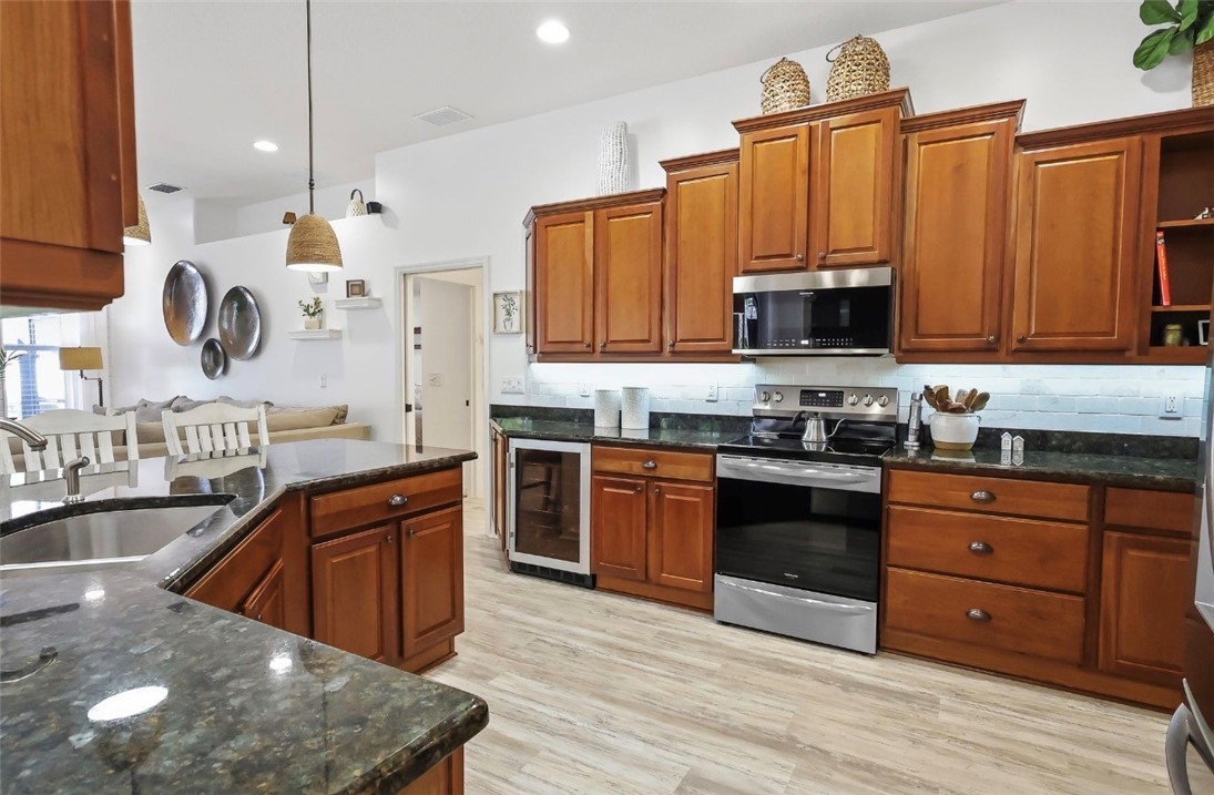 1771 Mistletoe Street Sebastian, FL 32958 - Photo 9 of 36 a kitchen with stainless steel appliances granite countertop a stove a sink and a microwave