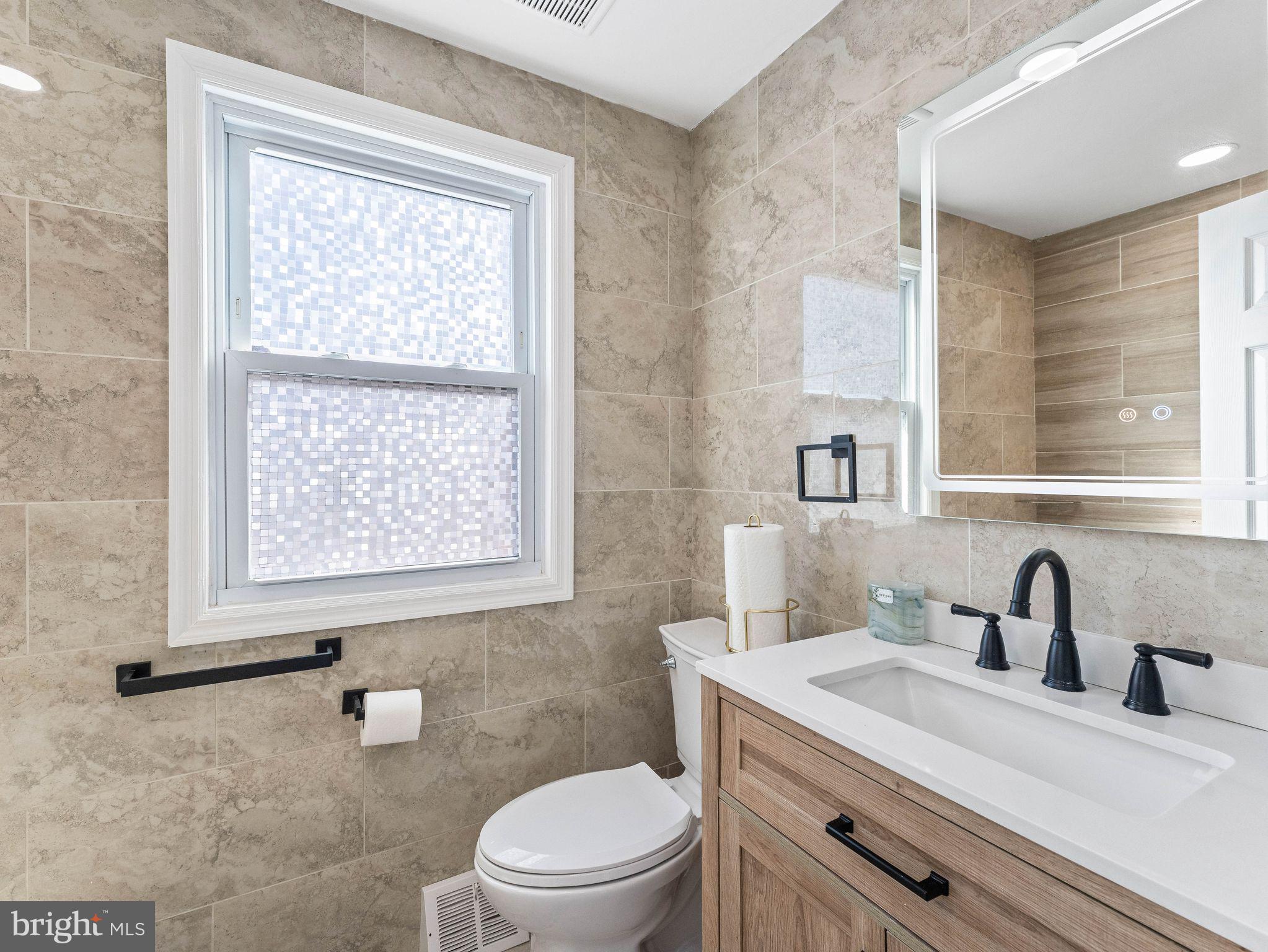 1152 Morefield Road Philadelphia, PA 19115 - Photo 16 of 29 a bathroom with a sink a toilet and a window