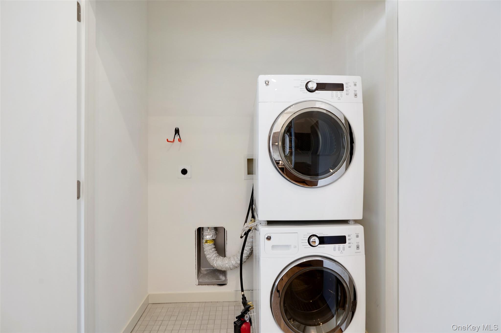 2 2nd Street, Unit 34 Rye, NY 10580 - Photo 6 of 6 Laundry room with tile patterned floors, baseboards, stacked washer and clothes dryer, and laundry area