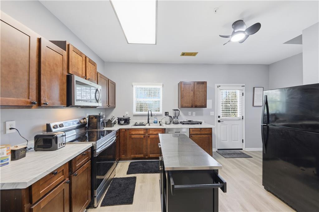 2166 Braxton Road Southwest Atlanta, GA 30331 - Photo 5 of 19 a kitchen with stainless steel appliances granite countertop a sink dishwasher stove and refrigerator with wooden floor