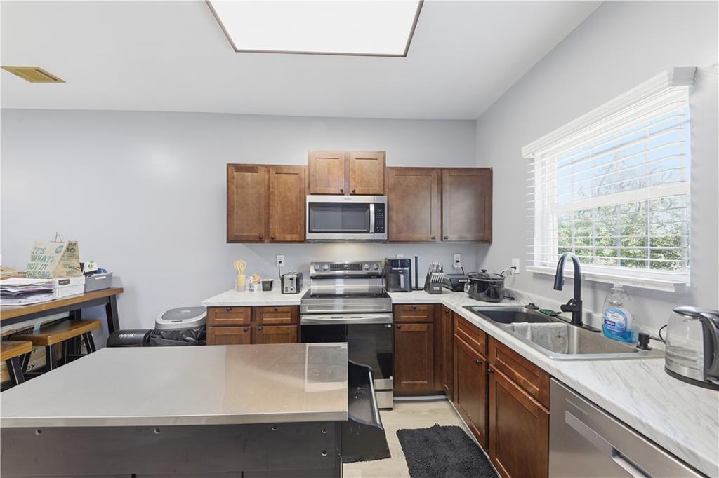 2166 Braxton Road Southwest Atlanta, GA 30331 - Photo 6 of 19 a kitchen with a sink a stove and cabinets