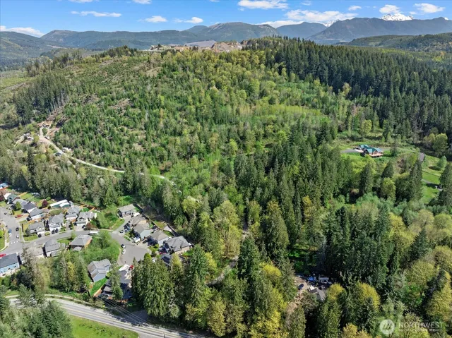 an aerial view of a houses with a green yard