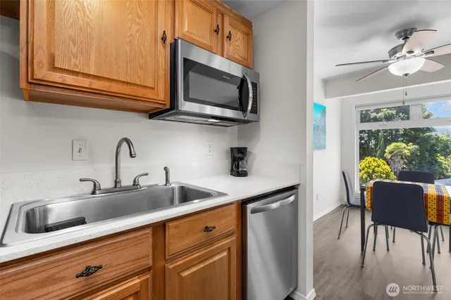 a kitchen with stainless steel appliances granite countertop a sink a microwave cabinets and wooden floor