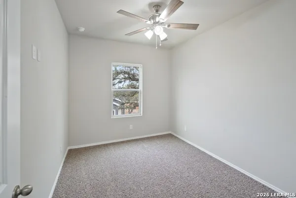 an empty room with a window and a fan