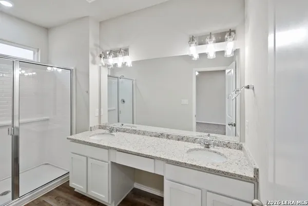 a bathroom with a granite countertop sink and a mirror